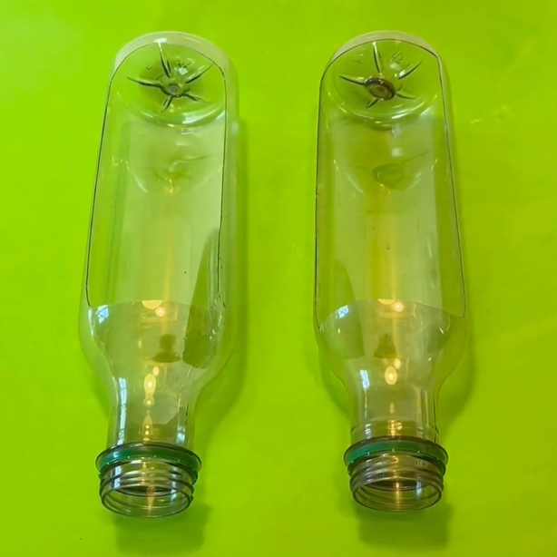 two empty plastic bottles with parts cut out in the middle