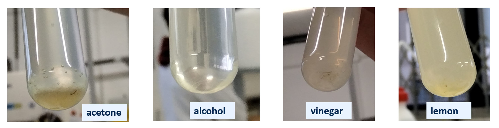 four test tubes with differently coloured liquids, the tubes are labeled: acetone, alcohol, vinegar, lemon