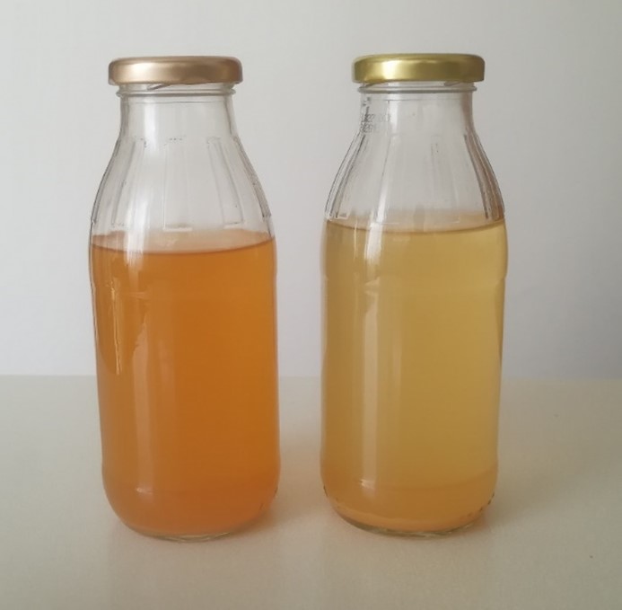 Two glass bottles filled with self-made apple vinegar, the vinegars have two different yellow colours