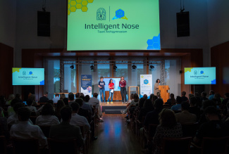A group of people is standing on stage in front of an audience