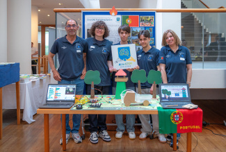 Students and teachers standing behing a table