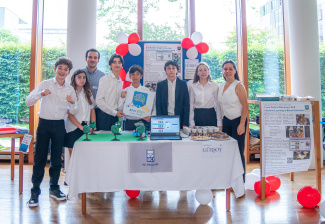 Students and teachers standing behind a table