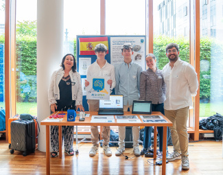 A group of people standing behind a table