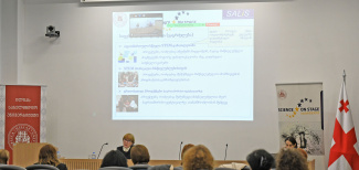 Speaker and attendants in front of a monitor in a seminar room