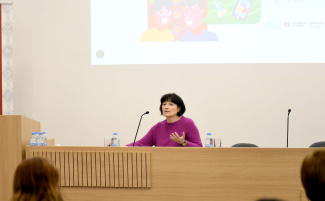 A presenter in front of a screen