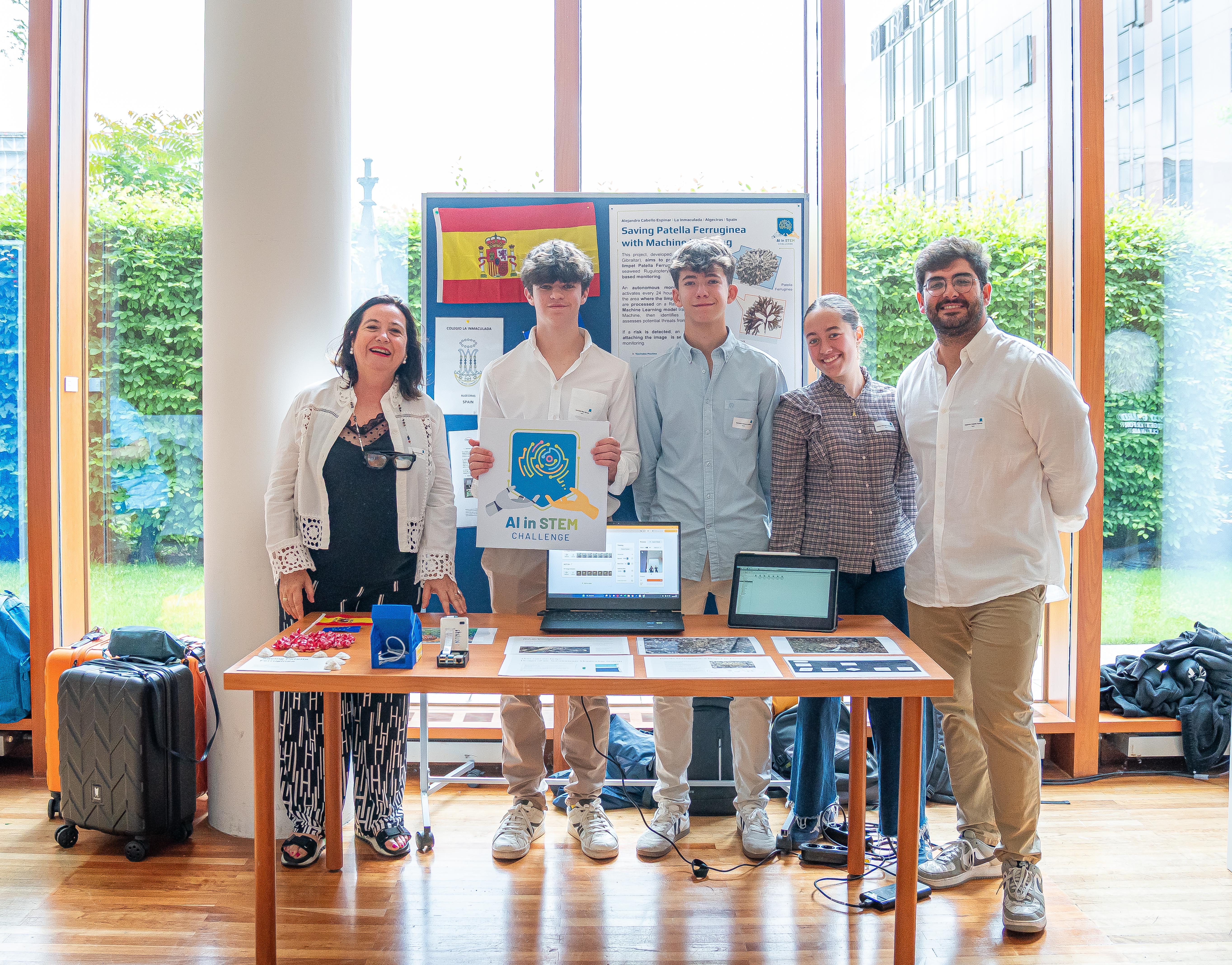 A team of two teachers and three students at their stand during a science competition