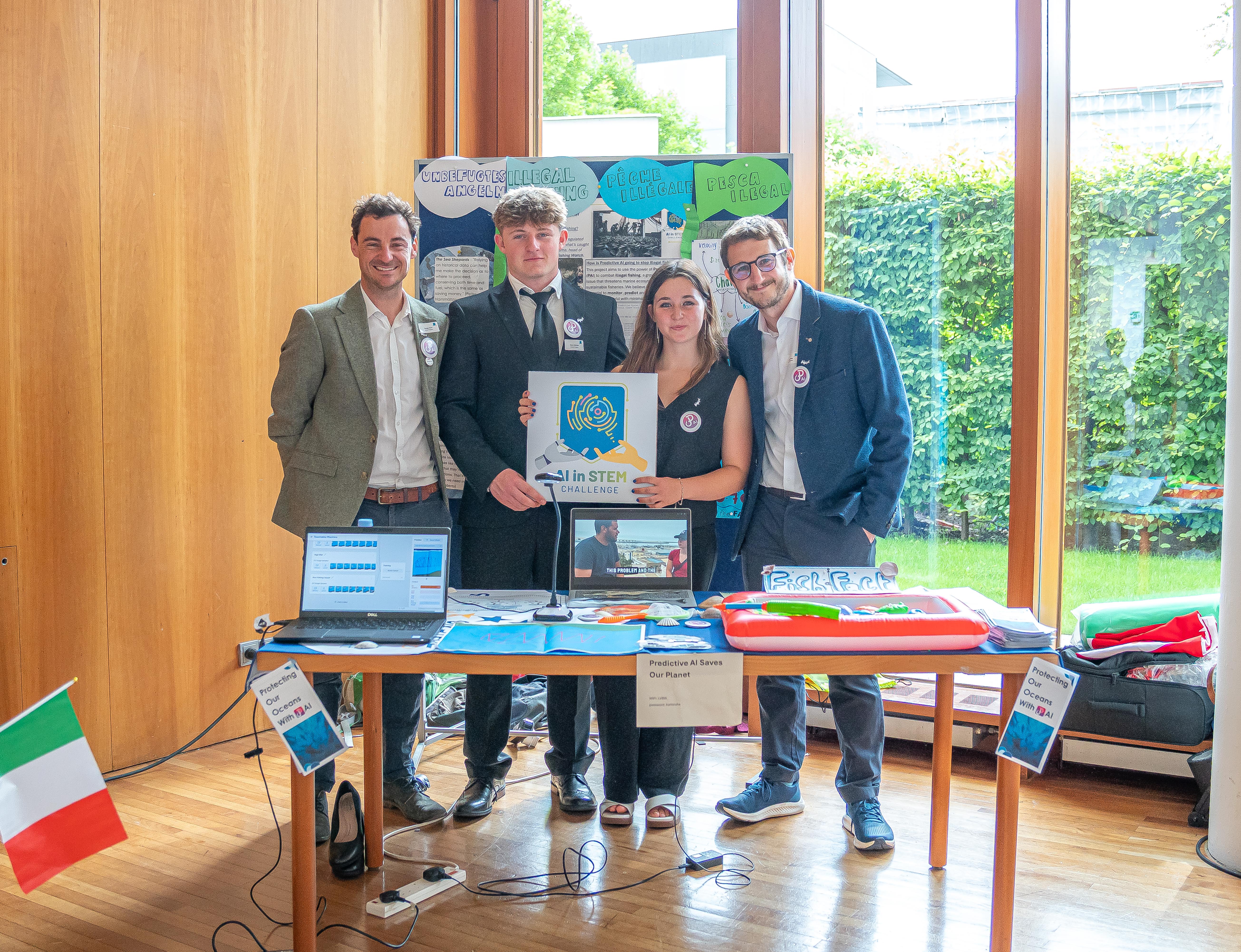 A team of two students and two teachers at their stand for a science exhibition