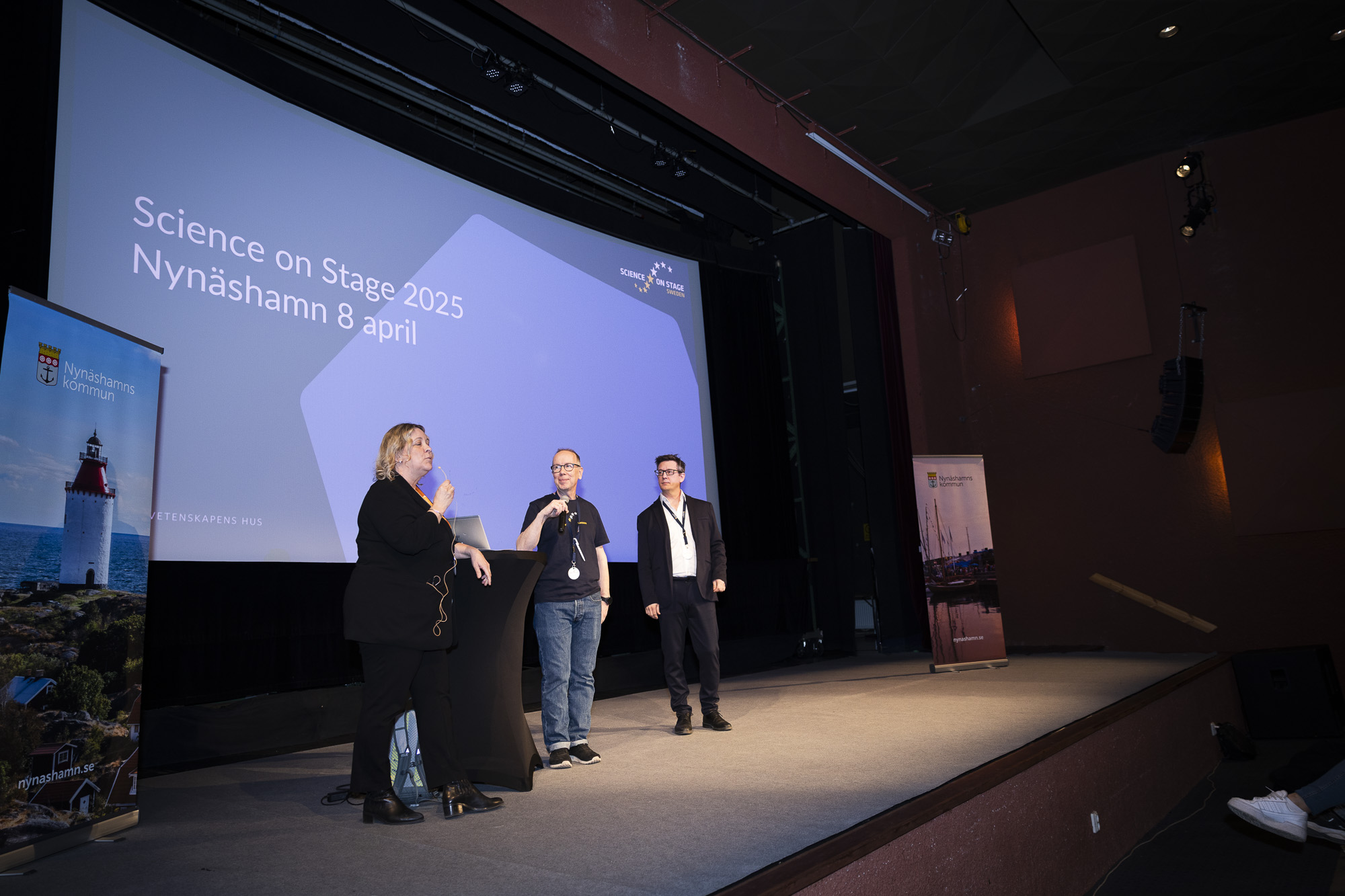 Three people standing on a stage