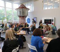 A group of teachers in a seminar hall decorated with a lighthouse