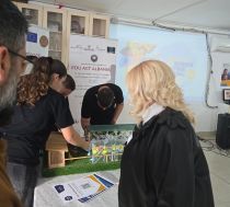 Four people observing a science experiment on a table