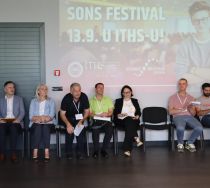 A row of teachers sitting underneath a screen displaying the Science on Stage Serbia festival