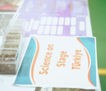 A card saying "Science on Stage Türkiye" on a table with science exhibits