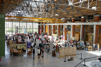 view of a fair with stands inside a big hall