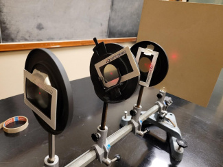 Setup with three polarisation filters: the polarisation directions of the two at the ends are perpendicular to each other, the polarisation direction of the one in the middle is tilted by 45° with respect to the horizontal direction.
