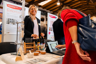 A visitor and an exhibitor at a stand at the education fair