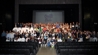 Group picture of over hundred conference participants in an auditorium