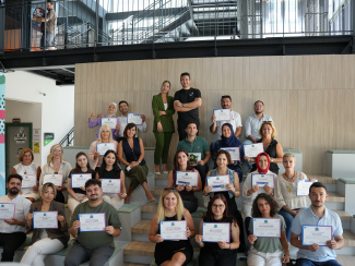 A workshop group photo with the participants holding their certificates