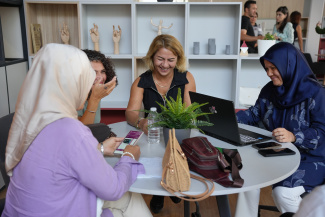 Four female teachers engaged in a workshop group activity