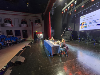 A podium with two people on a spacious stage