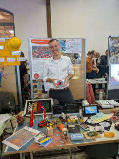 An exhibitor at a trade fair stand with colorful exhibits