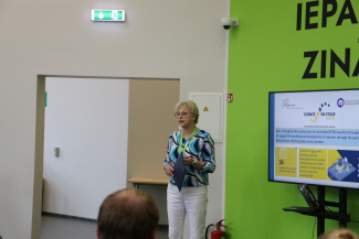 A speaker next to a monitor during a seminar