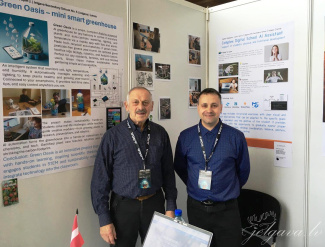Two teachers in front of their project posters at a science exhibition