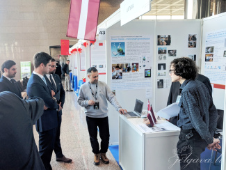 A group of exhibition visitors at a stand