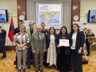 A group of eight people with an award certificate at a conference venue