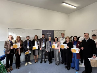 A group of conference participants holding award certificates