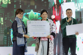 Three people on a stage holding an award certificate