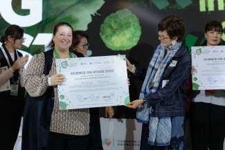 Two people holding a big award certificate