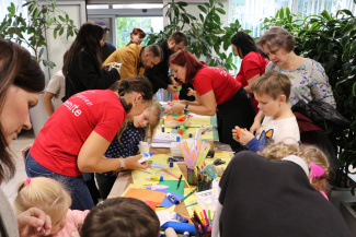 A group of children and adults bent over a workshop table