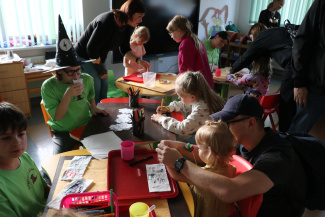 A group of children crafting objects at a workshop table