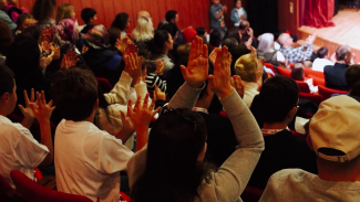 Cheering audience in an auditorium seend from behind