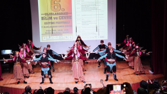 Children doing a folk dance in traditional costumes on stage