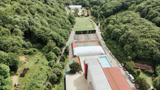 A school campus in the middle of green woods seen from above
