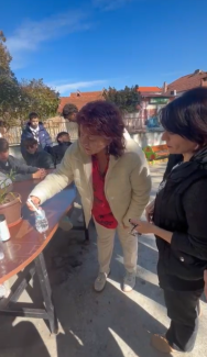 Two women inspect a science experiment with a water bottle