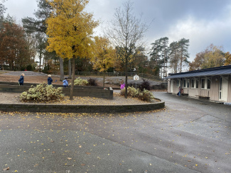 A view of a school's yard with a few children in the background