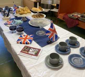 A table with a British flag, cups and a display of baked savoury snacks
