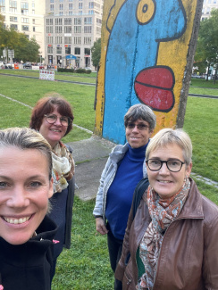 Four women in front of colourful artwork in a park