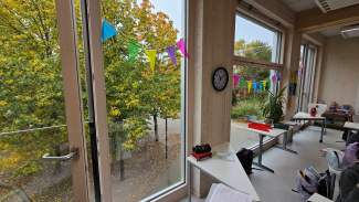 View of the glass front of a classroom, with  trees outside