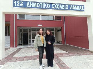 Two women in front of a Greek school