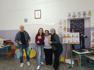Four people in a classroom decorated with drawings